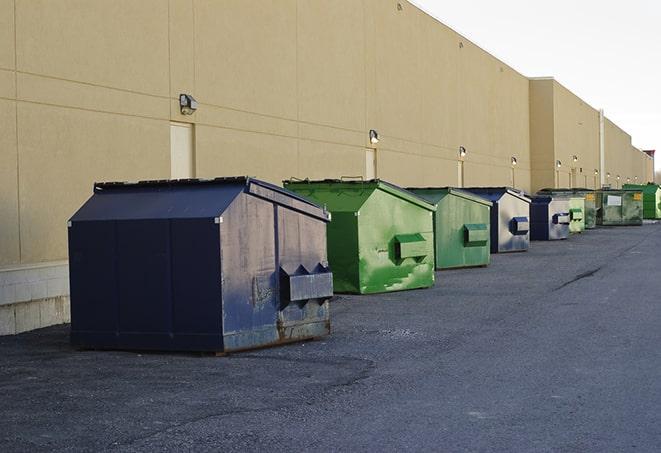 a row of yellow and blue dumpsters at a construction site in Avondale AZ